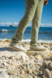 Detalle de las alpargatas Peñíscola Hielo, una sneaker con suela de yute natural cosida a mano en España con materiales sostenibles y aroma a cítricos. Detalle de alpargata frente al mar. 