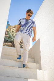 Modelo en unas escaleras blancas con las sneakers Mallorca Denim de MYBARKS, hechas en España de forma artesanal con materiales sostenibles y diseño mediterráneo.