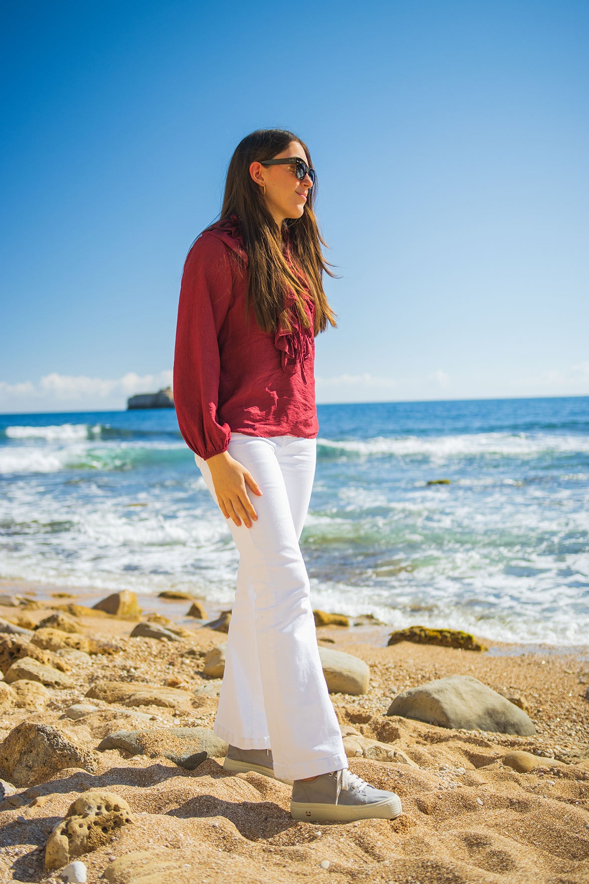 Modelo con las zapatillas Nápoles Gris de MYBARKS en la playa. Las sneakers de MYBARKS están hechas en España con materiales sostenibles y aroma a pino mediterráneo. 