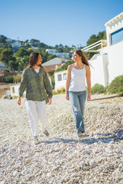 Dos chicas llevando zapatillas MYBARKS. La primera modelo va con las Verona Gris, hechas en España de forma artesanal con materiales sostenibles, mientras que la segunda luce las Verona Negro. Calzado con aroma a pino mediterráneo. 